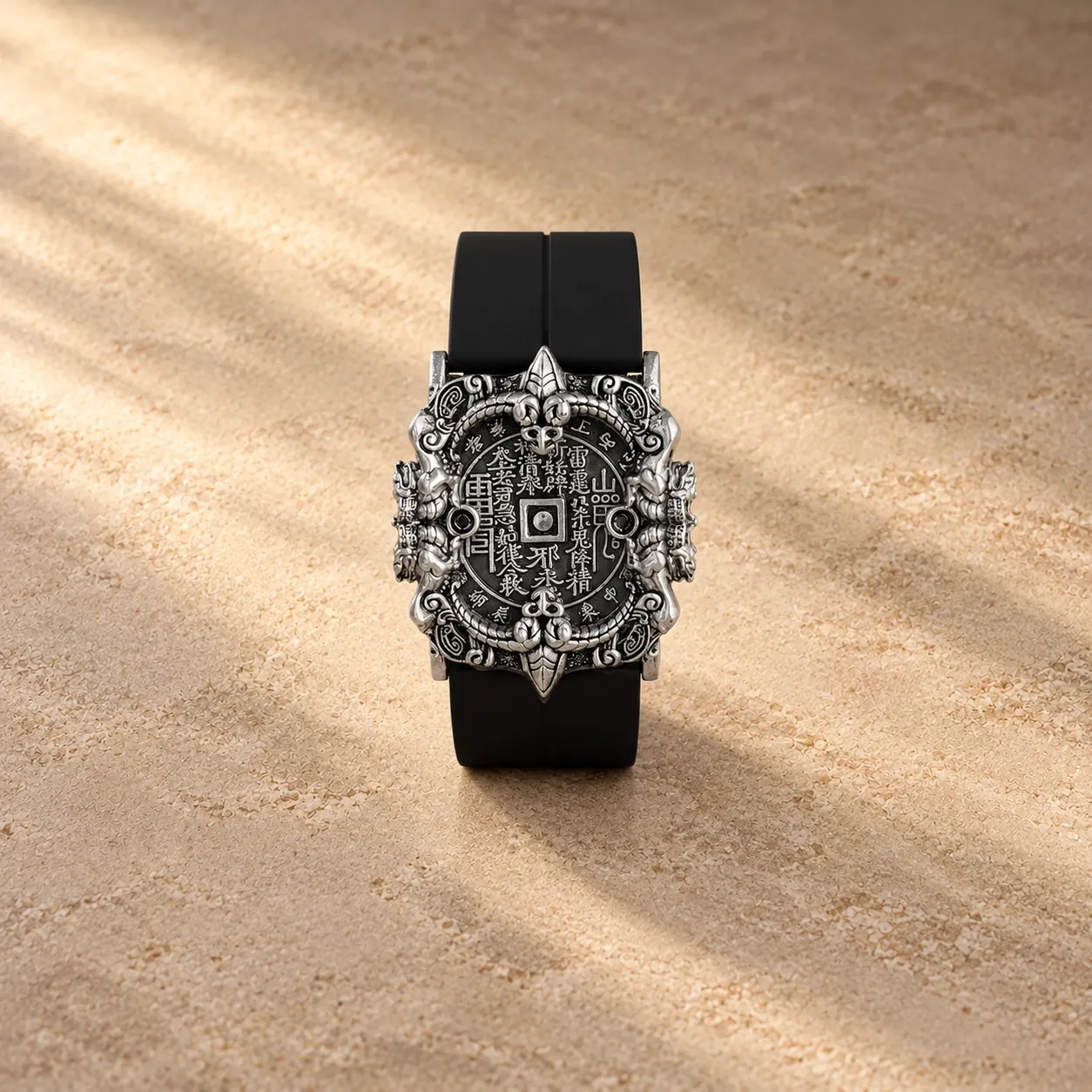 A black strap bracelet with an ornate silver-plated amulet coin plaque