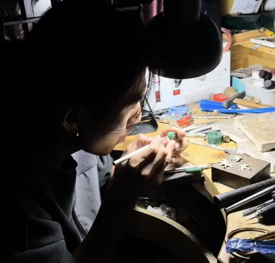 A maker shaping a piece at the workbench