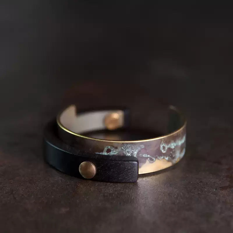 Patina copper and ebony wood cuff bracelet on dark stone