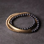 Copper and black lava bead wrap bracelet coiled on dark stone
