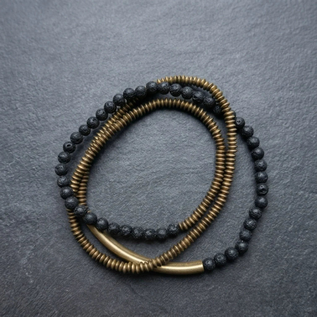 Copper heishi and black lava bead strand looped on slate