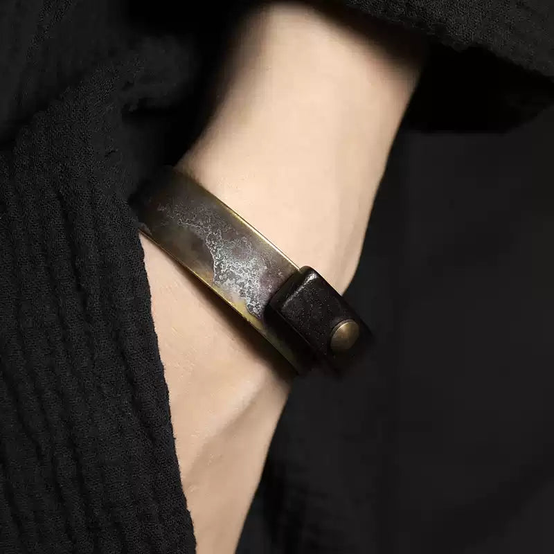 Copper and ebony cuff bracelet worn on the wrist with a black linen sleeve