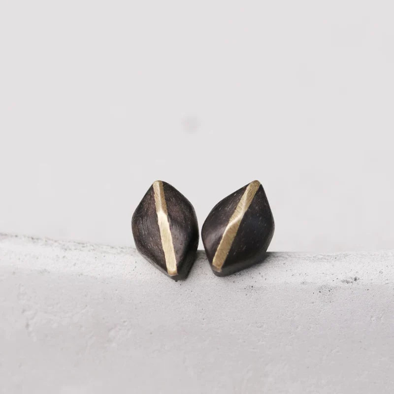 Front view of diamond-shaped ebony wood studs with a copper stripe