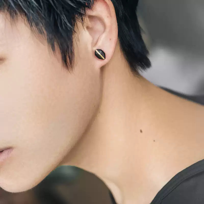 Man wearing a single ebony wood stud earring with copper inlay