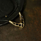 Close-up of the organic openwork copper pendant on black cord