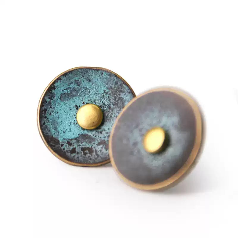 Round verdigris copper disc stud earrings on white
