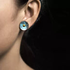 Woman wearing a round verdigris copper disc stud earring