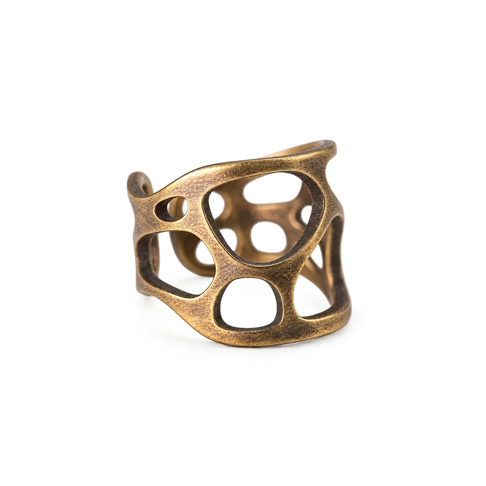 Wide sculptural openwork copper ring with organic cutouts, white background