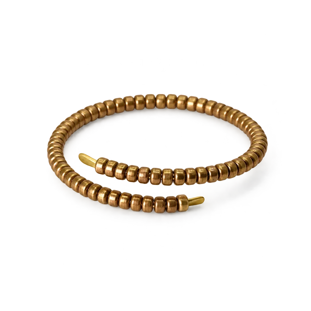 Coiled copper wrap bracelet made of segmented copper beads with flat tapered ends, white background