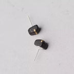 Ebony wood stud earrings laid flat showing the earring posts