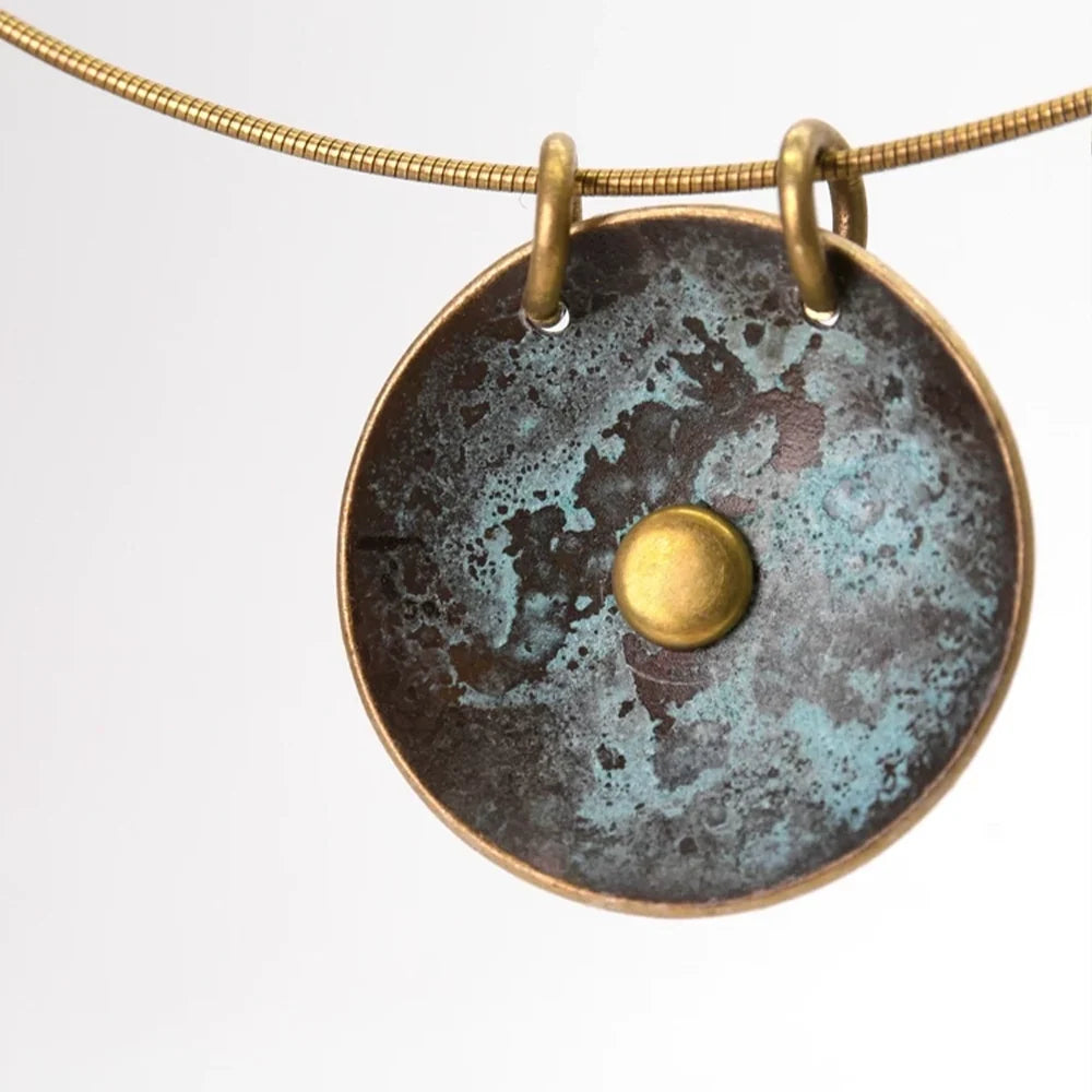 Close-up of the concave verdigris copper disc pendant with domed copper center