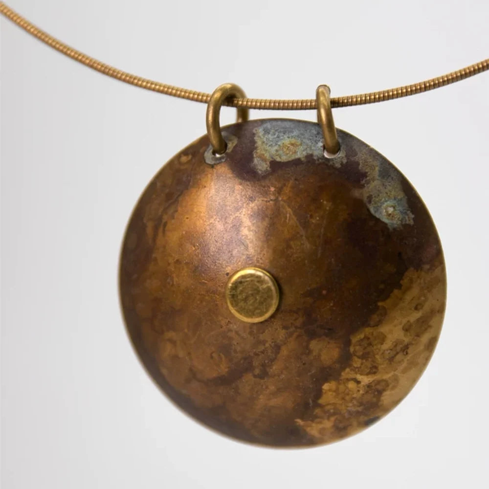 Back of the copper disc pendant showing its warm natural copper finish