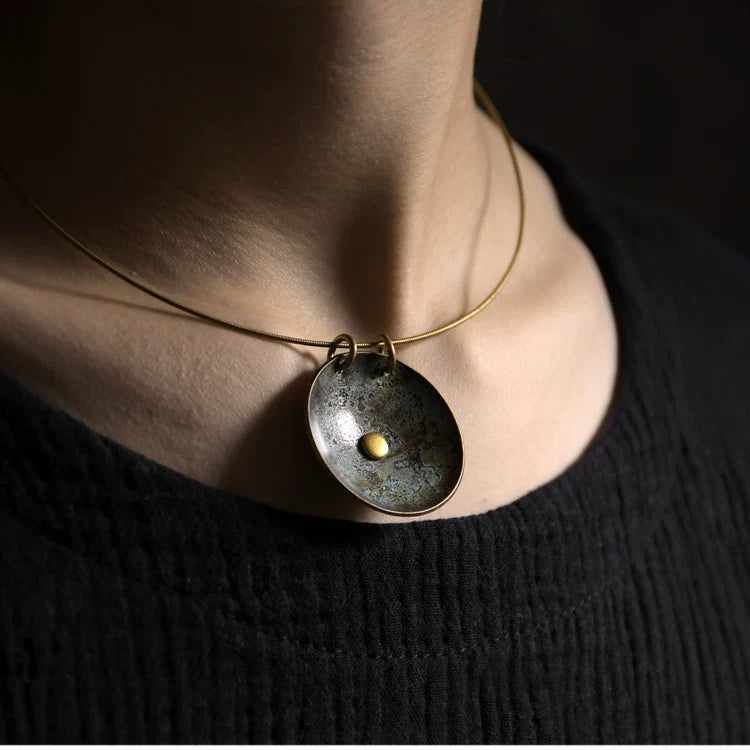 Close-up of the copper disc pendant necklace worn at the collarbone