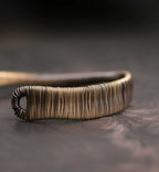 Close-up of tightly coiled copper wire wrapping at the cuff end