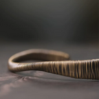 Side profile of the wire-wrapped copper cuff showing its twist