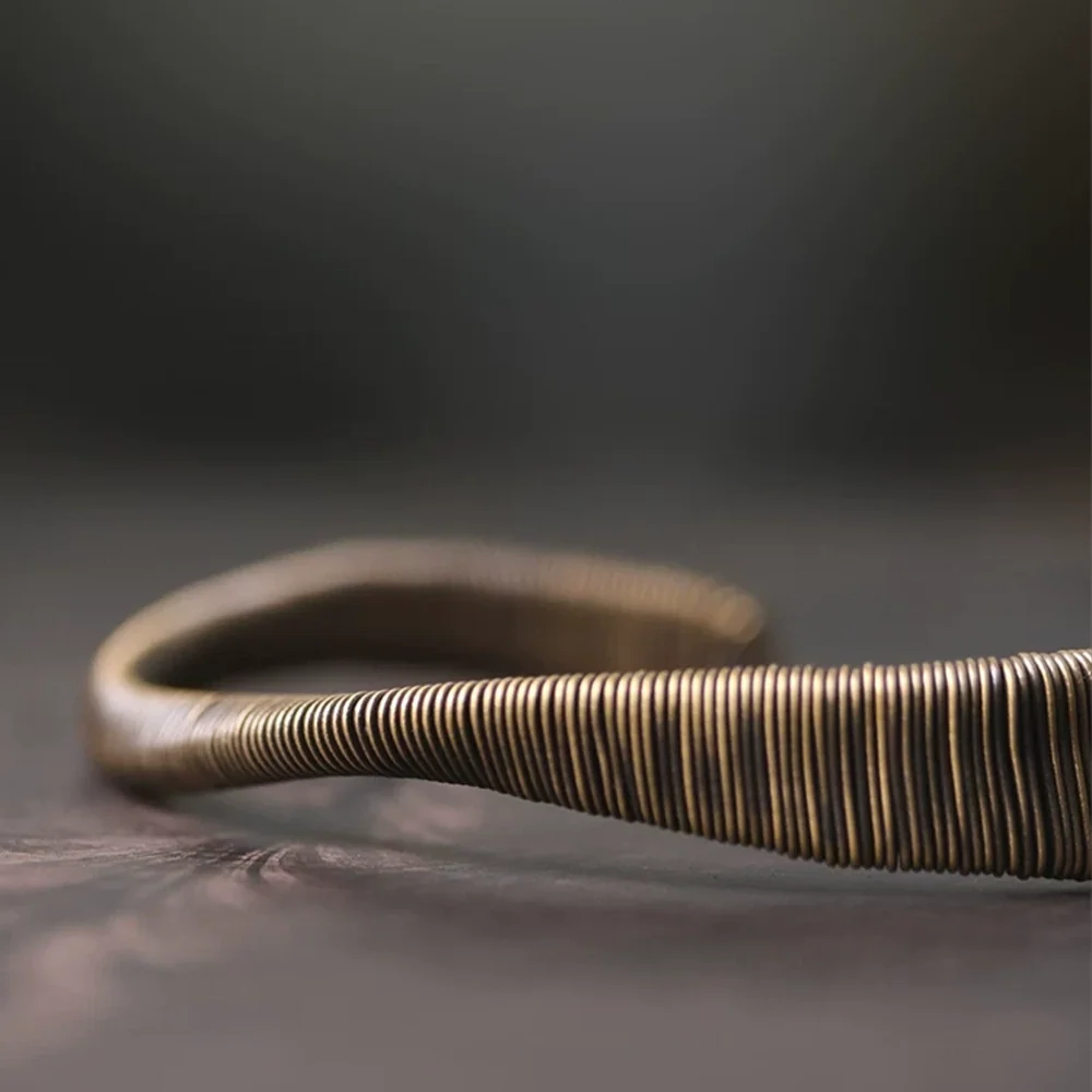 Side profile of the wire-wrapped copper cuff showing its twist