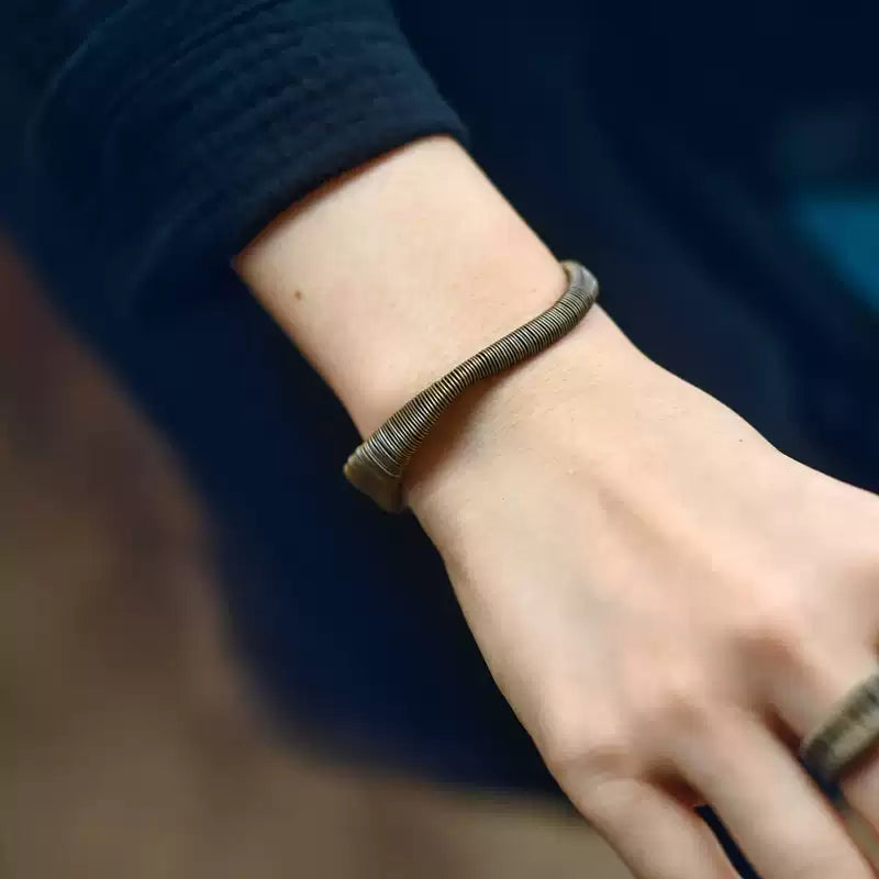 Wire-wrapped copper cuff worn on the wrist, shown with a matching ring