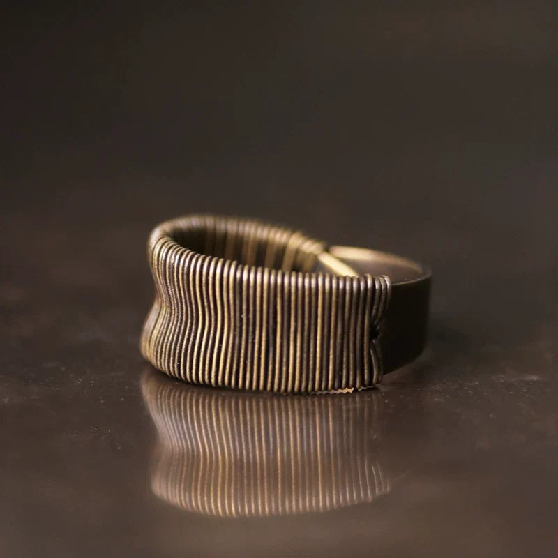 Close-up of fine coiled copper wire wrapping on the wide ring band